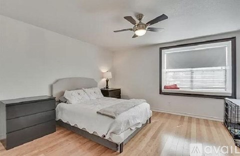 A bedroom with a bed, dresser, and window.