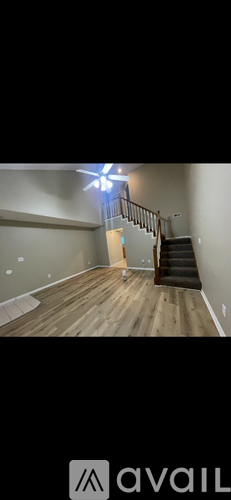 A room with wooden flooring and a staircase.