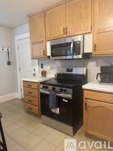 A kitchen with wooden cabinets and a black stove top oven.