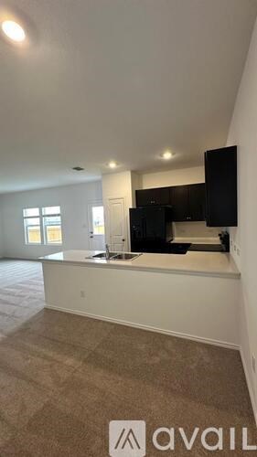 A room with a carpeted floor and a white counter.