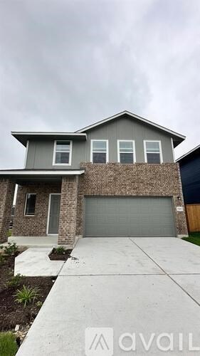 A house with a grey garage door and a grey roof.