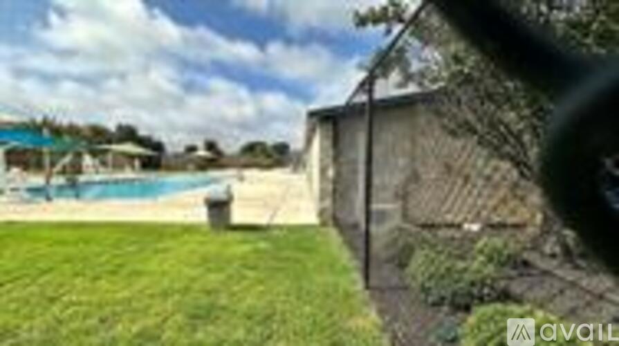 A pool is surrounded by a grassy area.