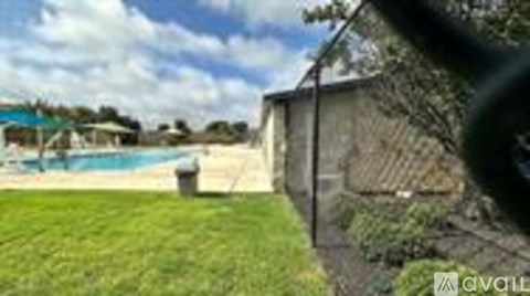A pool is surrounded by a grassy area.
