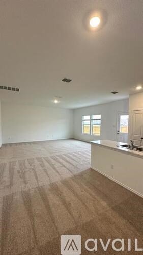 A room with a carpeted floor and a window.