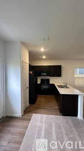 A kitchen area with a sink and a television.