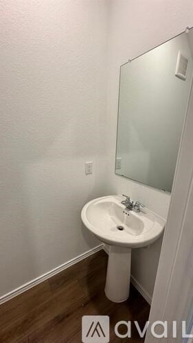 A white pedestal sink in a small bathroom.