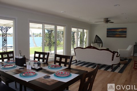A dining room with a table set for four and a view of the water.
