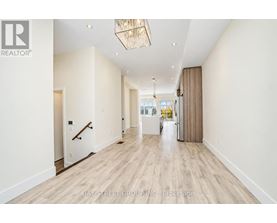 A hallway with a light wood floor and white walls.
