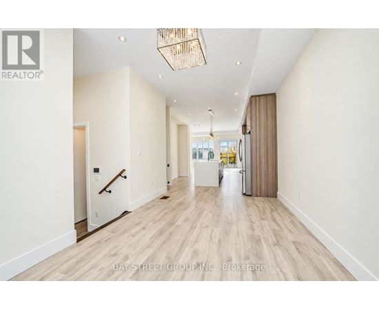 A hallway with a light wood floor and white walls.