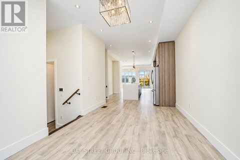 A hallway with a light wood floor and white walls.