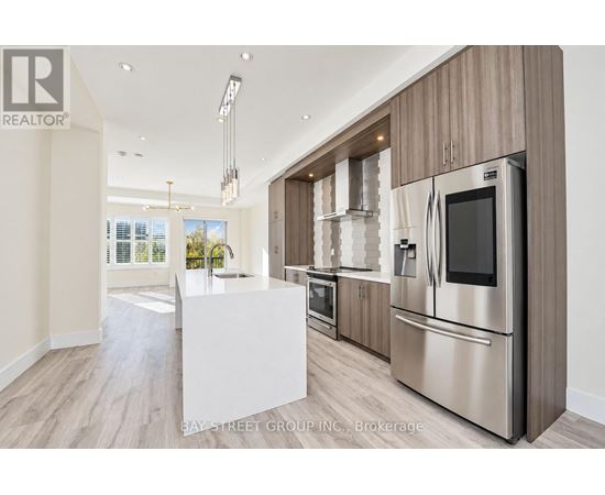 A modern kitchen with stainless steel appliances and wooden cabinets.
