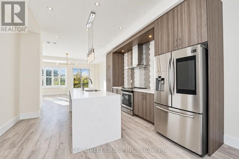 A modern kitchen with stainless steel appliances and wooden cabinets.