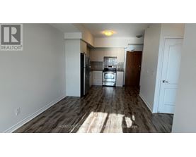 A kitchen with white walls and a wooden floor.