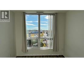 A room with a window showing a view of a street with cars and buildings.