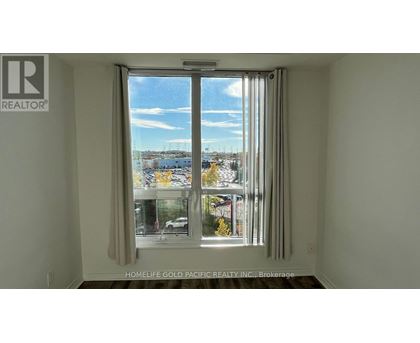 A room with a window showing a view of a street with cars and buildings.