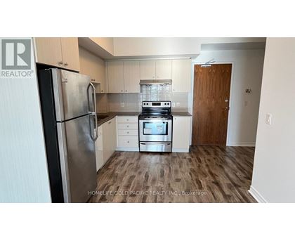 A kitchen with a refrigerator, oven, and cabinets.