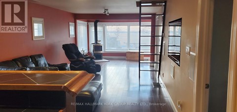 A living room with a black leather couch and a wooden coffee table.
