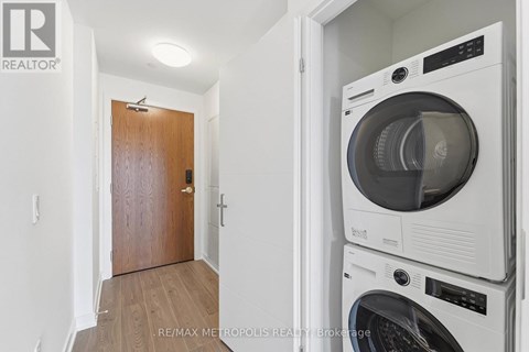 A white washing machine and dryer stacked on top of each other in a small room.