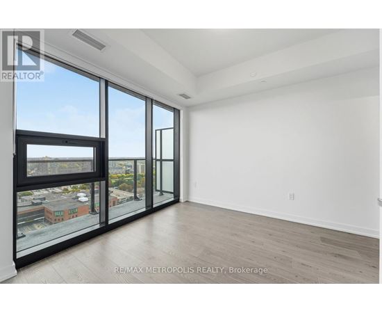 A spacious room with large windows and a view of the city.