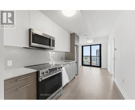 A modern kitchen with a stainless steel microwave above the stove.