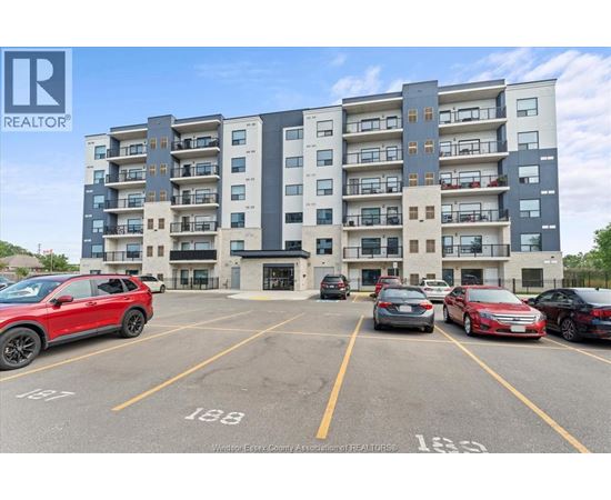 A parking lot with cars and a building in the background.