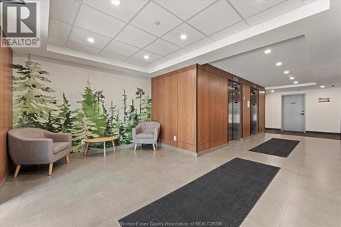 A well-lit office lobby with a green plant wall and a wooden reception desk.