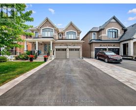 A large, well-maintained house with a driveway in front.