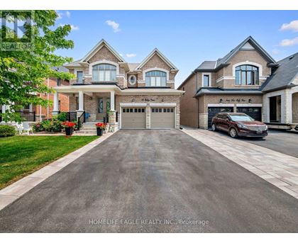 A large, well-maintained house with a driveway in front.