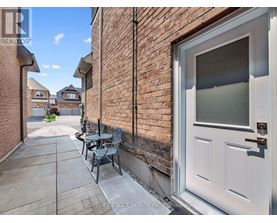 A white door is on the right side of a brick wall.