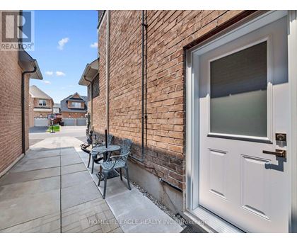 A white door is on the right side of a brick wall.
