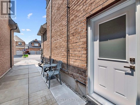 A white door is on the right side of a brick wall.