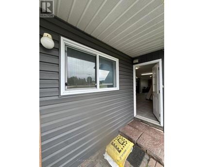 A house with a grey siding and a white door.
