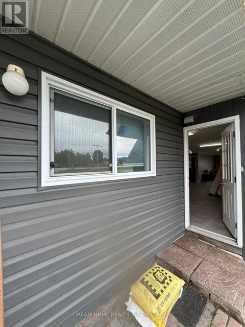 A house with a grey siding and a white door.