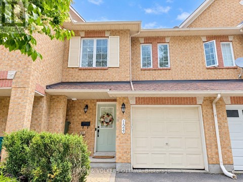 A house with a white garage door and a wreath on the door.