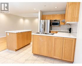 A kitchen with wooden cabinets and a stainless steel refrigerator.