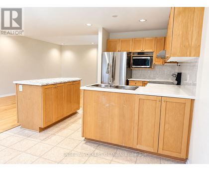 A kitchen with wooden cabinets and a stainless steel refrigerator.