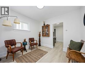 A living room with a brown chair and a wooden cabinet.