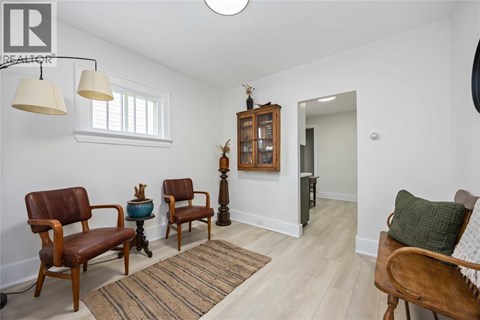 A living room with a brown chair and a wooden cabinet.