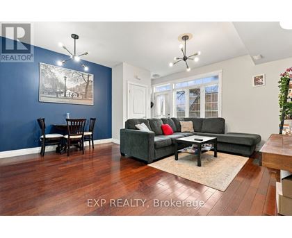 A living room with a grey couch and a wooden floor.