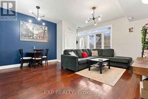 A living room with a grey couch and a wooden floor.