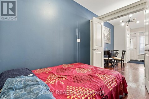 A bedroom with a bed covered in a red and gold comforter.