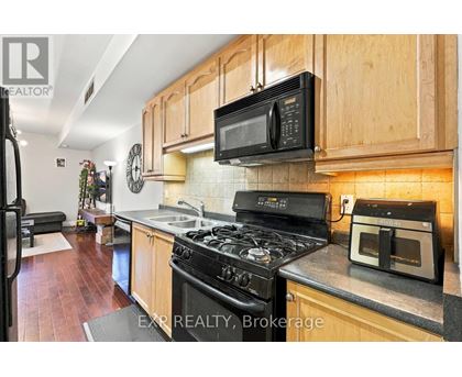 A kitchen with a black stove top oven and a black microwave above it.