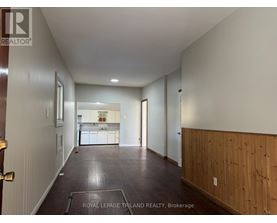 A long hallway with a kitchen visible in the distance.