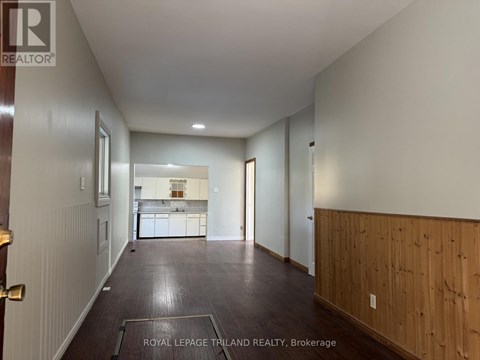 A long hallway with a kitchen visible in the distance.