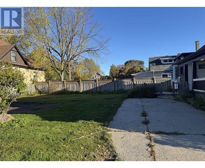 A residential area with a sidewalk and a grassy area.