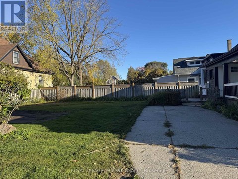 A residential area with a sidewalk and a grassy area.