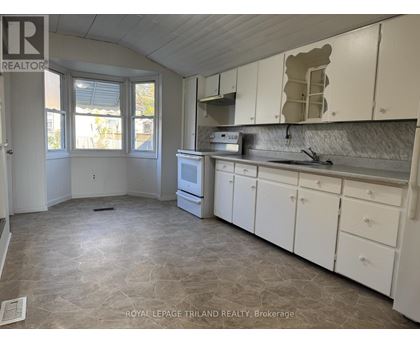 A kitchen with white cabinets and a tiled floor.