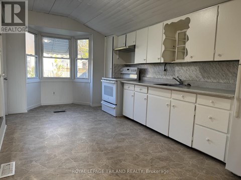A kitchen with white cabinets and a tiled floor.