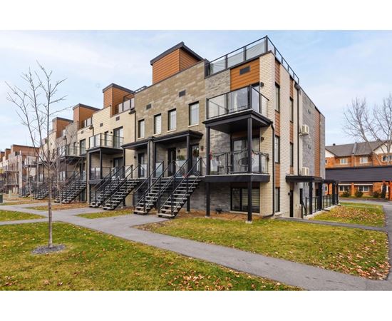 A modern apartment building with balconies and staircases.