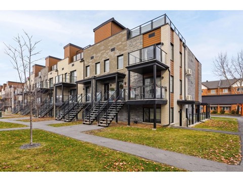 A modern apartment building with balconies and staircases.